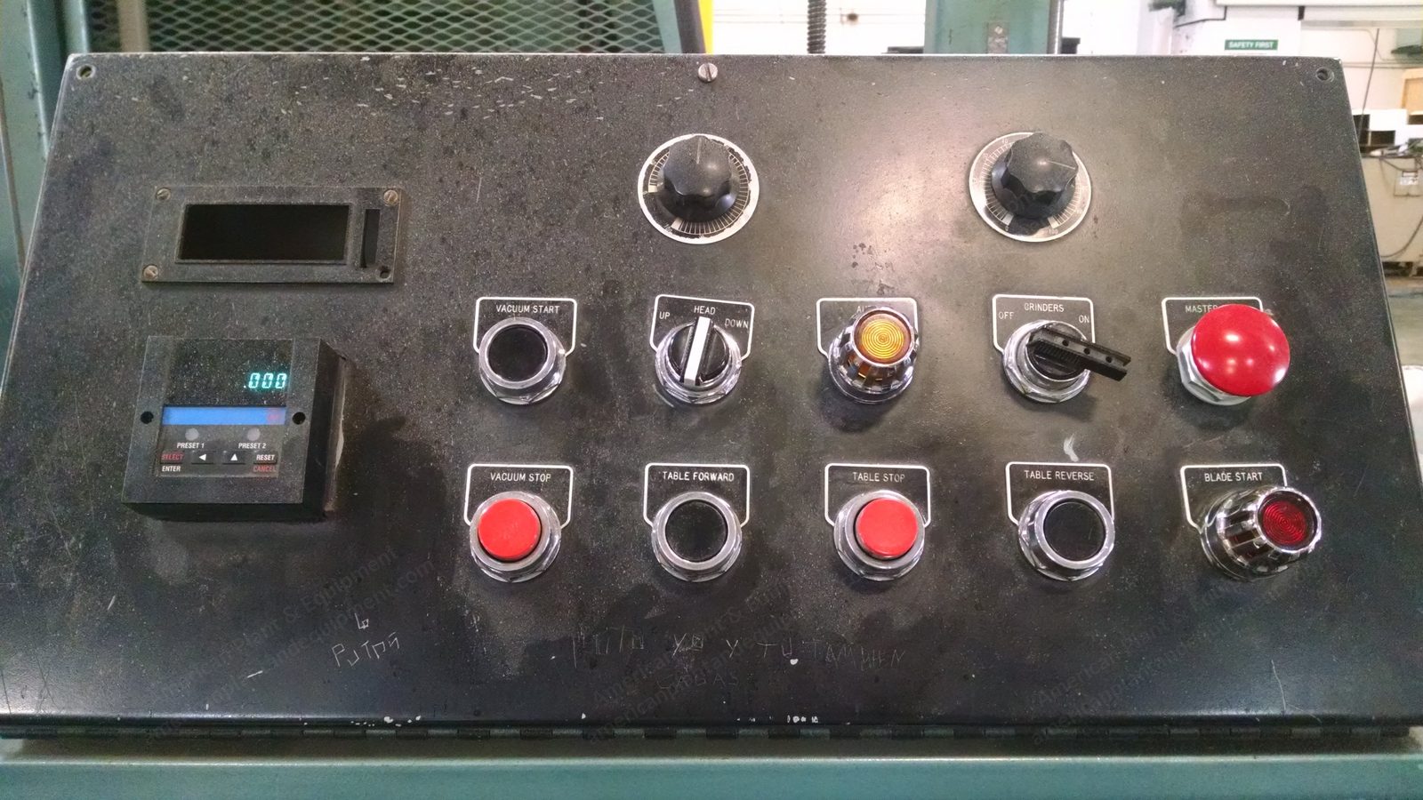 Push-button control panel on a horizontal foam saw, illuminated start and stop buttons.