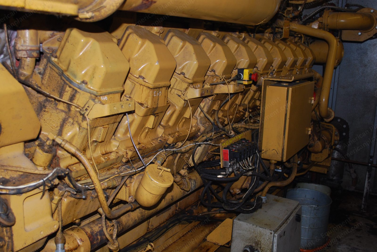 Large natural gas generator engine, cylinder banks and exhaust manifolds exposed.