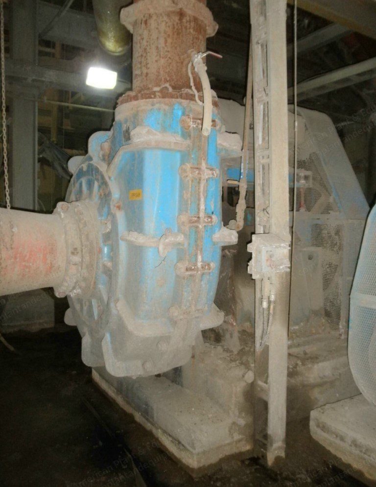 Centrifugal slurry pump with its motor and coupling guard in a process building.